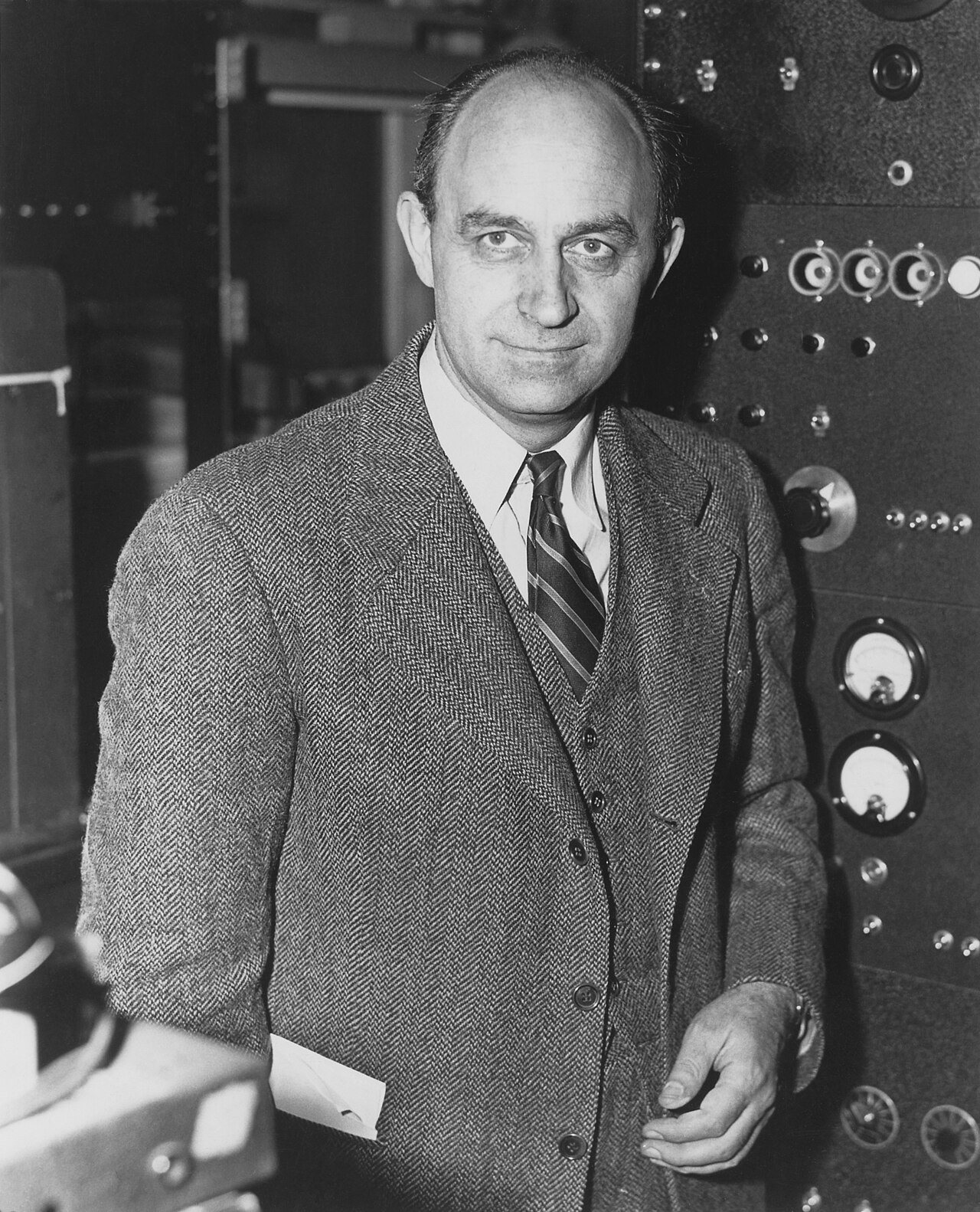 Enrico Fermi, dark-haired, in a suit, looking directly at the camera.